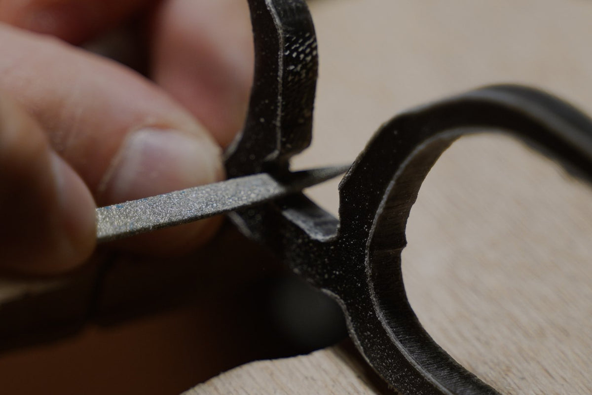 Woolet Bespoke - hands filing the bridge of an acetate frame, every pair cut to your measurements and hand made in Greece